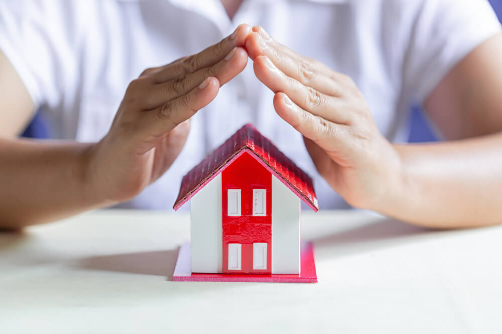 Navigating Housing Decisions and the VA Loan as a Military Family House keys and a small model home on a table, representing the major financial decision of buying a house with a VA loan.